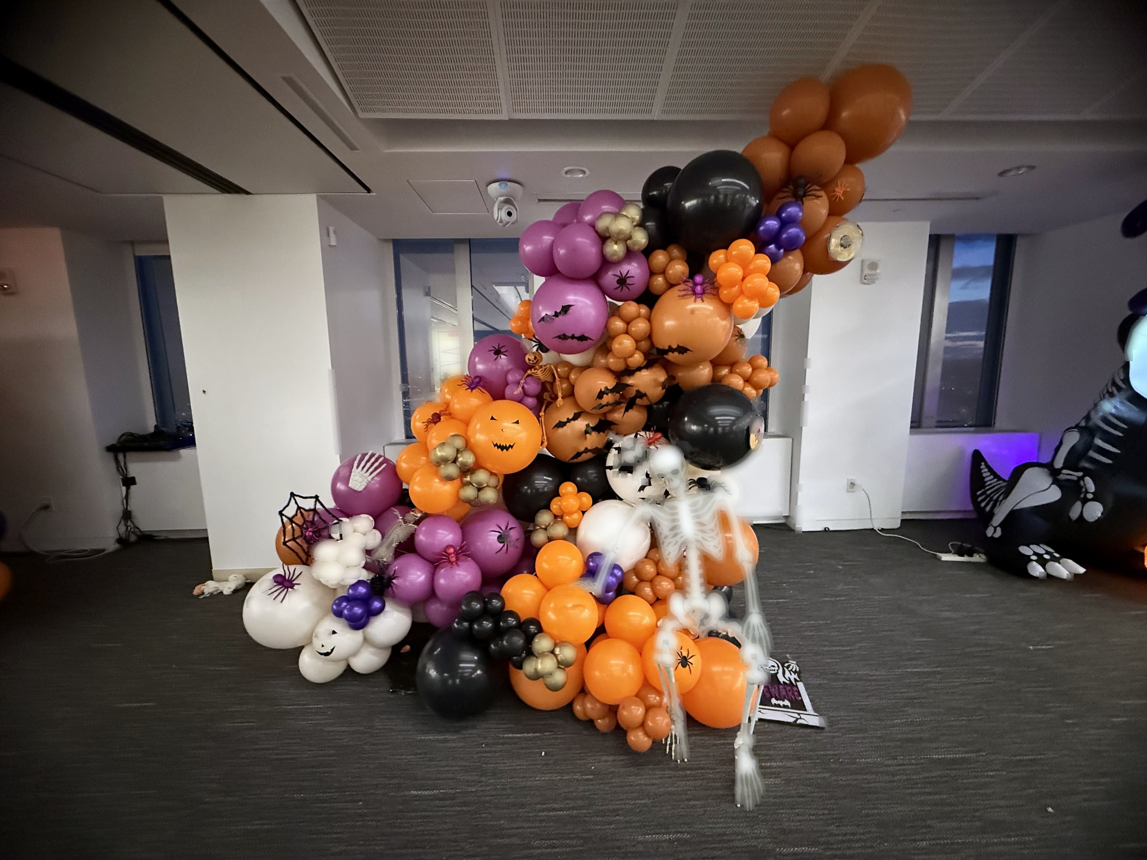 Dark and dramatic organic balloon garland with Halloween accents for a corporate event