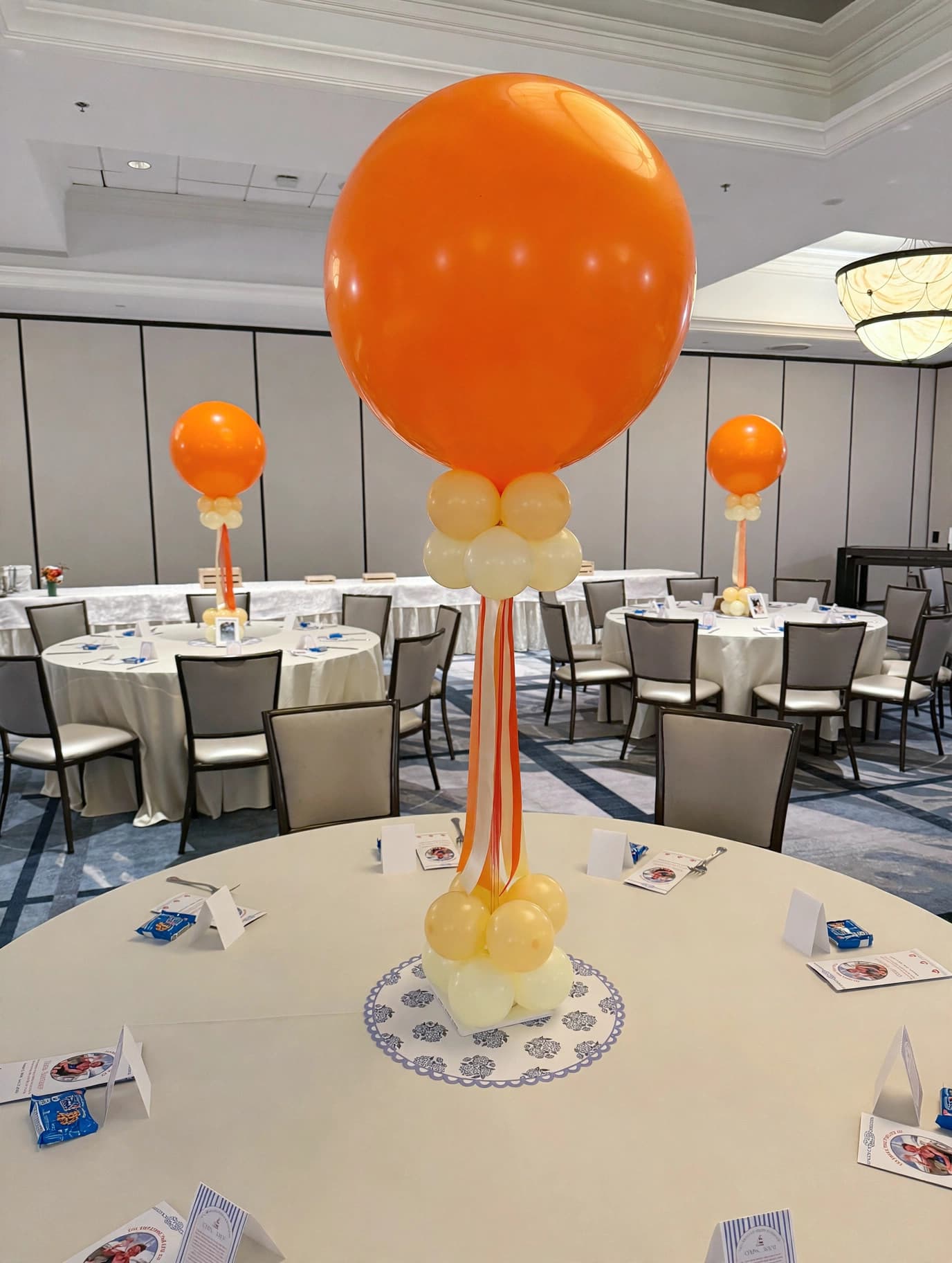 Classic orange balloon centerpiece with ribbon accents