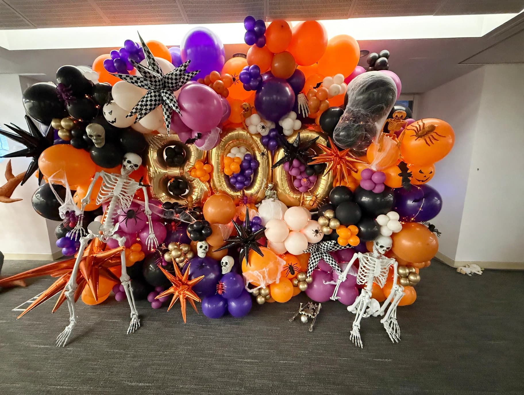 Halloween BOO balloon wall with skeleton accents for a corporate event