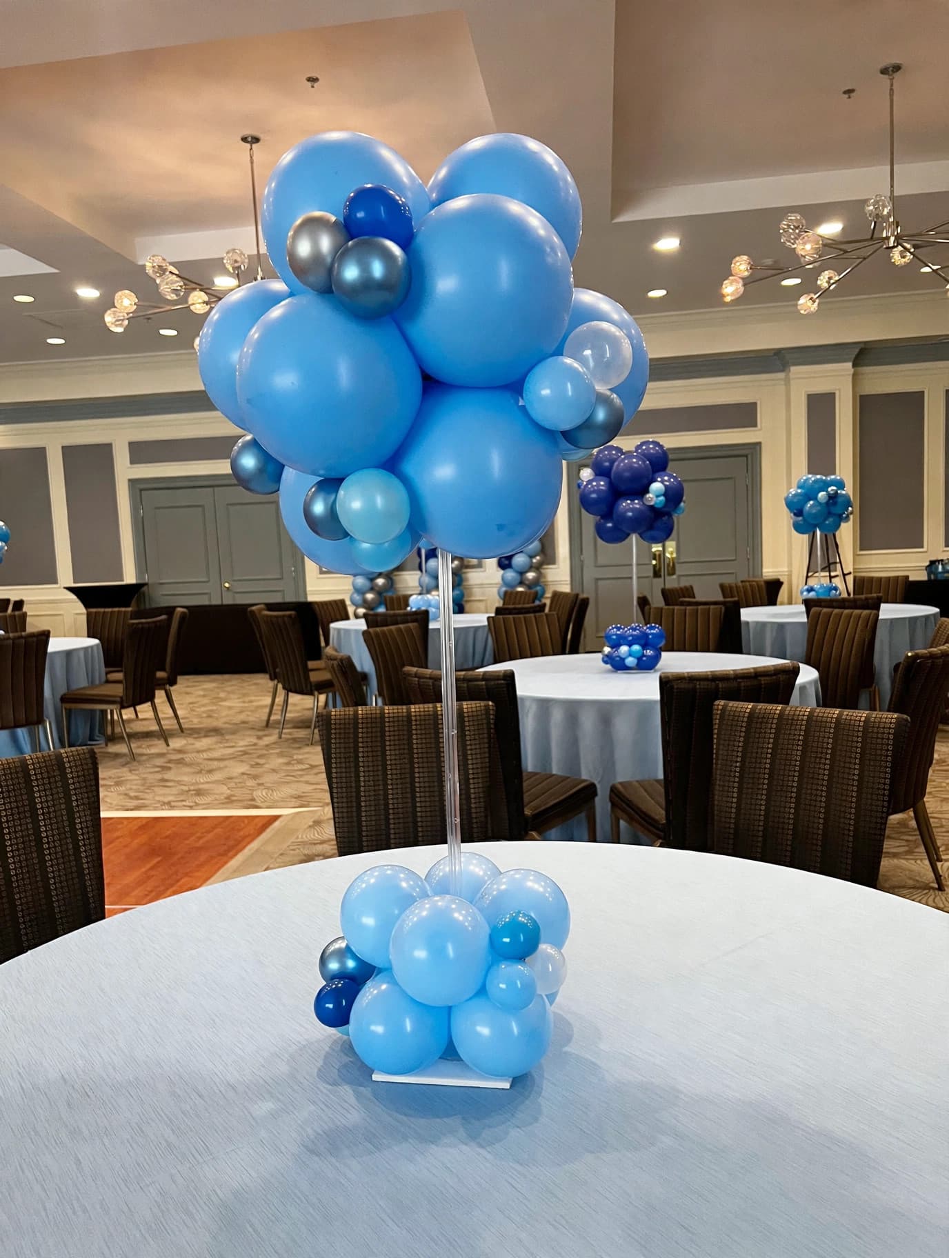 Blue and white balloon centerpiece clusters on tables