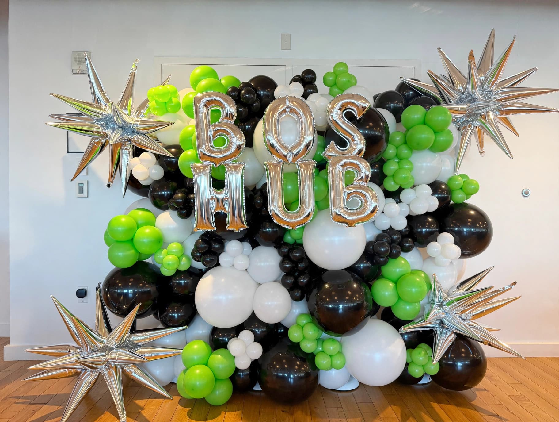 Green, black and white branded organic balloon wall for BOS HUB corporate activation