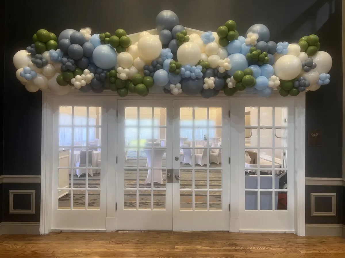 Sage, slate blue, and ivory organic balloon garland draped over residential French doors